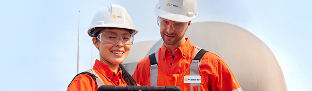 Two FortisBC employees looking at a tablet.