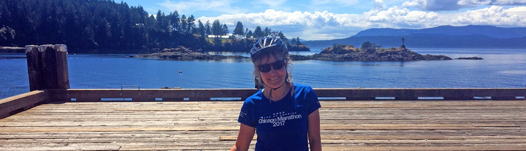 Penny Page-Brittin stands on a dock wit her bike