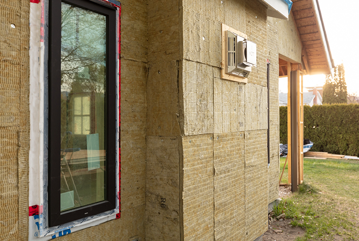 Exterior insulation sheathing being installed on the outside of the walls of the home