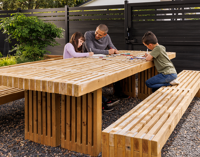 Shane and the kids enjoying their outdoor living space and custom picnic table and benches, purchased with FortisBC rebates dollars