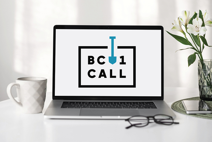 A laptop on a desk with the BC 1 Call logo on the screen