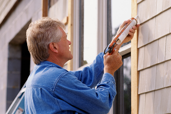 22-075-27-energysavings-blog-caulking-470x700 man caulks window exterior