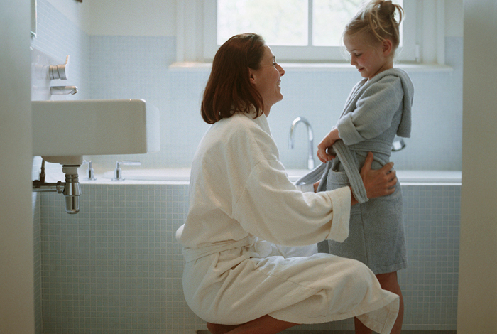 22-075-27-energysavings-blog-shower-470x700 mother stands with daughter in washroom near bathtub