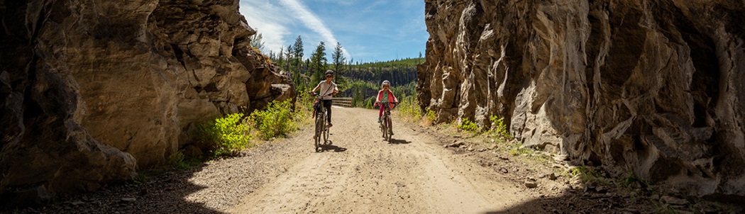 Two bike riders exploring Myra Canyon, BC