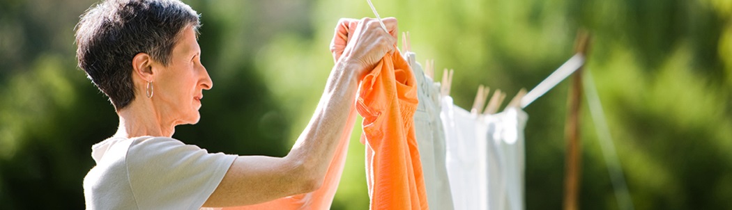 Woman hanging laundry on a clothes line outdoors
