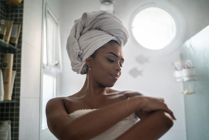 Woman wearing a towel getting out of a shower