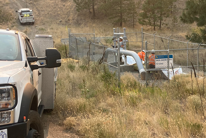 Operations crew members deploy fire blankets to protect gas transmission infrastructure in Sorrento, B.C.
