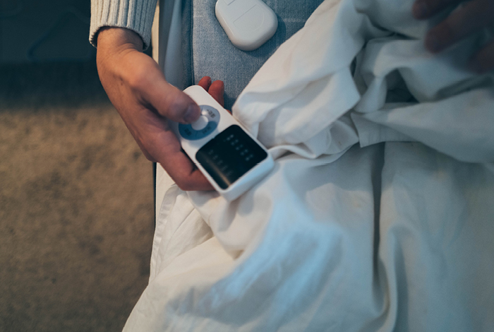 A person turning on a cozy heated blanket.