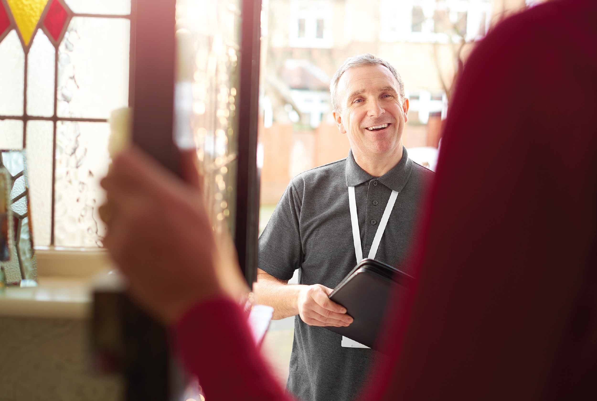 A woman greeting a solicitor at her home's doorway