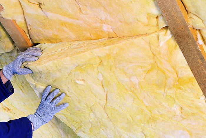 Close-up of batt insulation being installed.