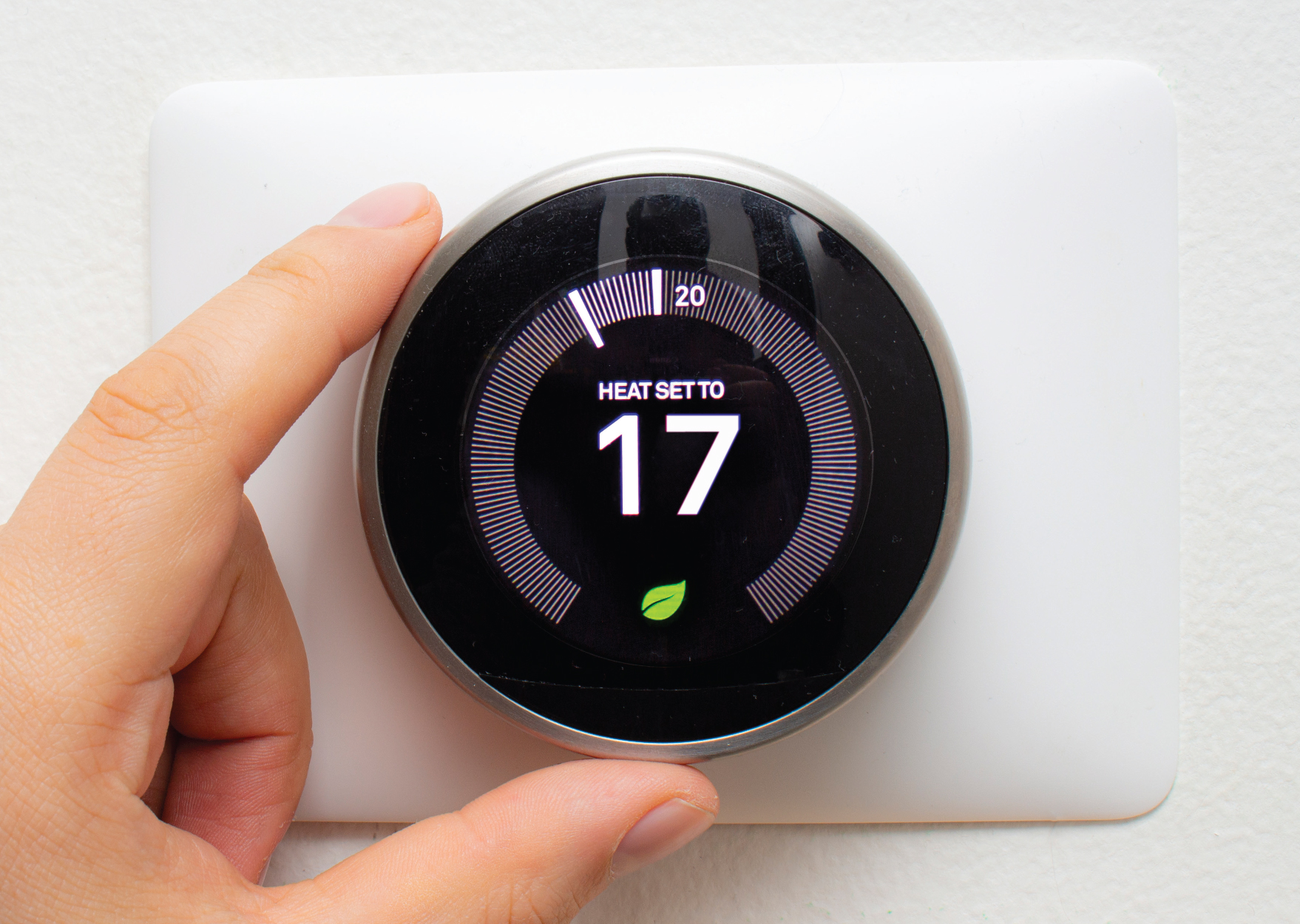 A thermostat being turned down to 17 degrees.