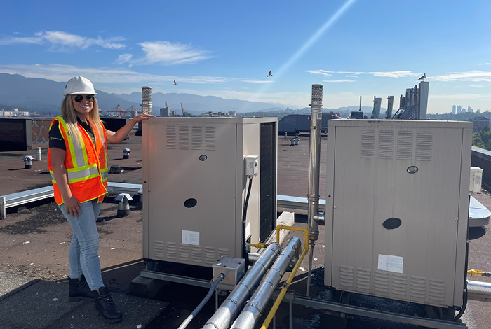 Mila Barbour standing by a gas heat pump