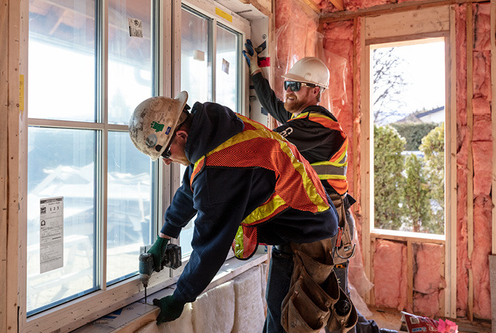 Two contractors installing windows in a home