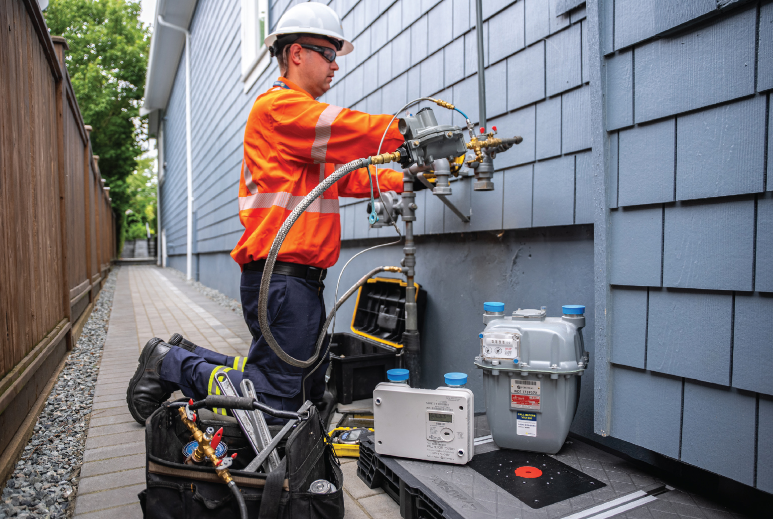 A technician exchanges an old gas meter for a new advanced gas meter at a residence.