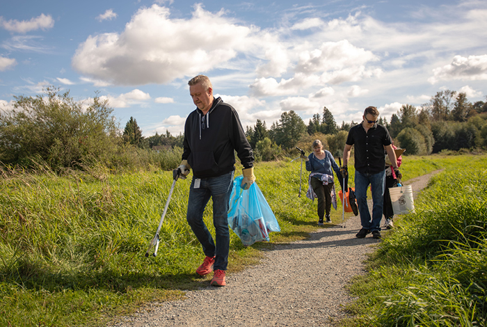 Volunteers Sam Nezirovic, technical support manager, Michelle Evans, director, people services, and Colin Murdoch, senior manager, employee and labour relations, cleaning up litter together on BC Rivers Day