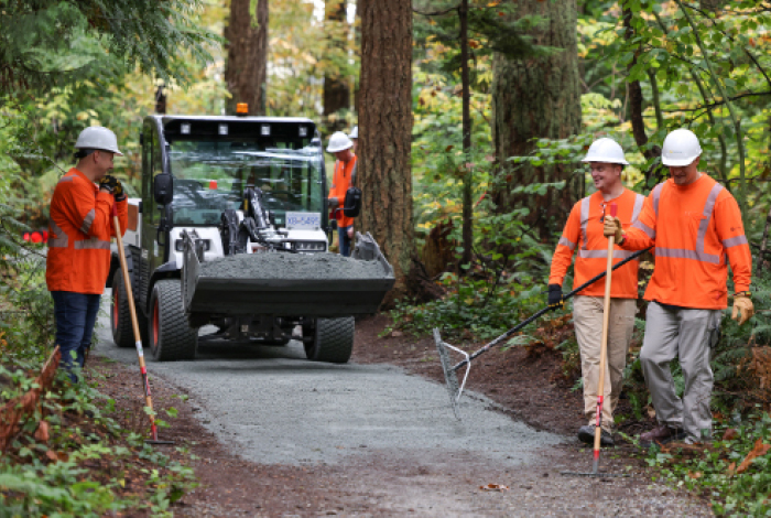 A team of operations managers from FortisBC resurfacing the trail in Wellington Park, Port Coquitlam