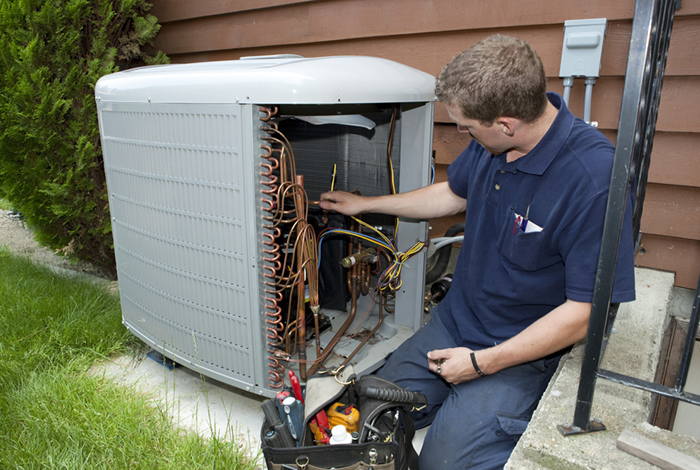 A contractor is inspecting an air-source heat pump