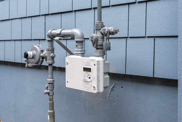 25-121-1-ami-winter-appt-blog-images an installed wireless advanced gas meter at the side of a house that is painted gray with gray shingles