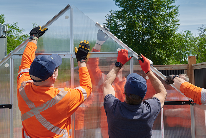 A team of volunteers from FortisBC, City of Campbell River and the Lookout Housing and Health Society building a greenhouse at Homewood Village in Campbell River.