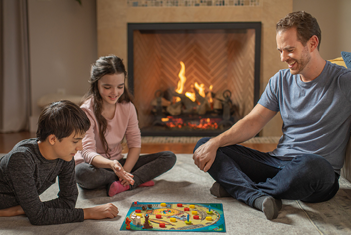 Family sitting on the floor playing a board game.