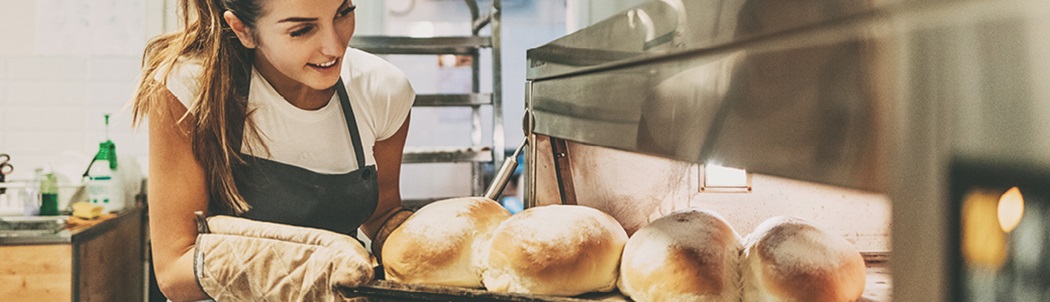 Person taking bread out of the oven.