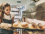 Person taking bread out of the oven.