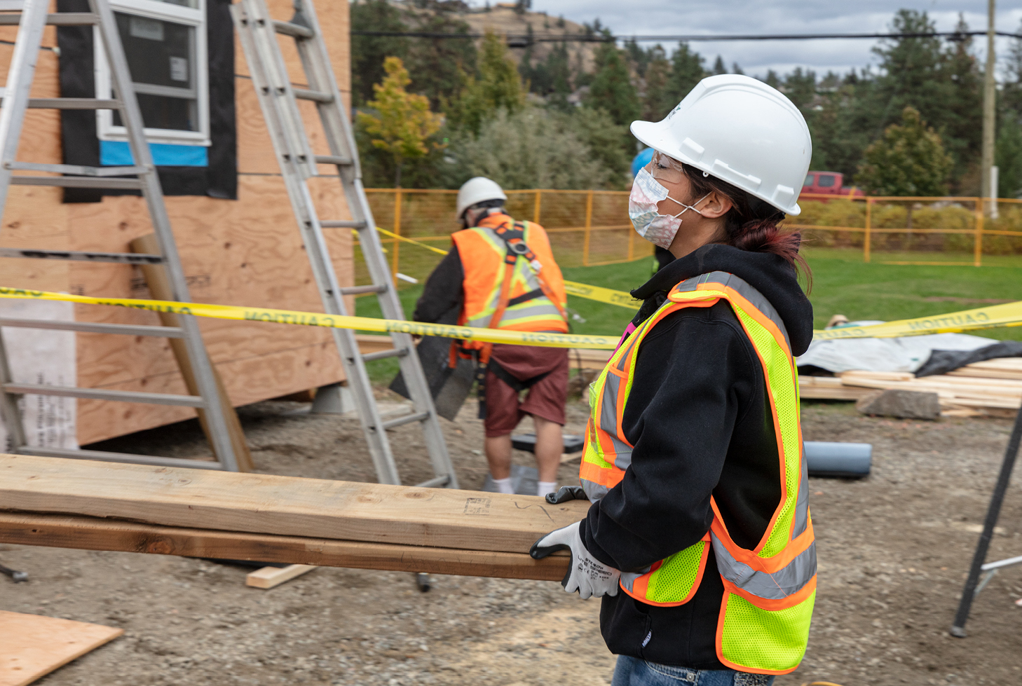 Worker helping to carry lumber