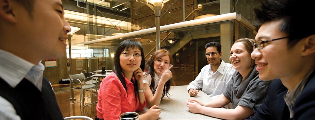 A group of recent grads listening intently to a mentor (18-150.26)