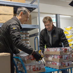 Two men stocking a shelf