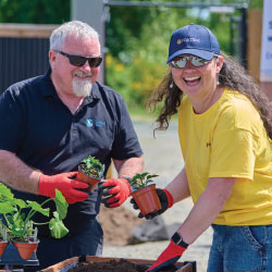 Two people holding plants
