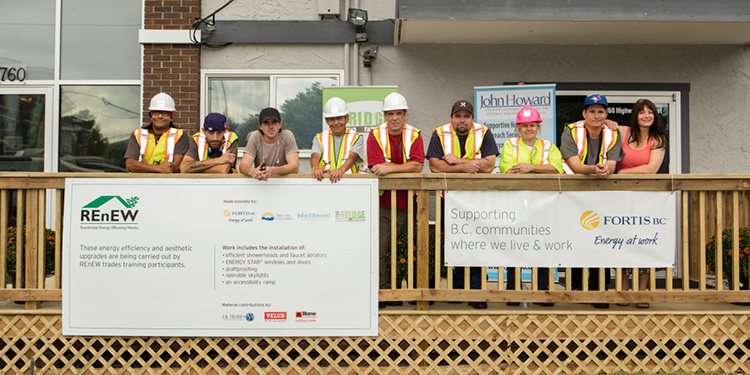 A group of recent grads of the REnEW program standing on the front deck of an apartment building  (18-150.11)