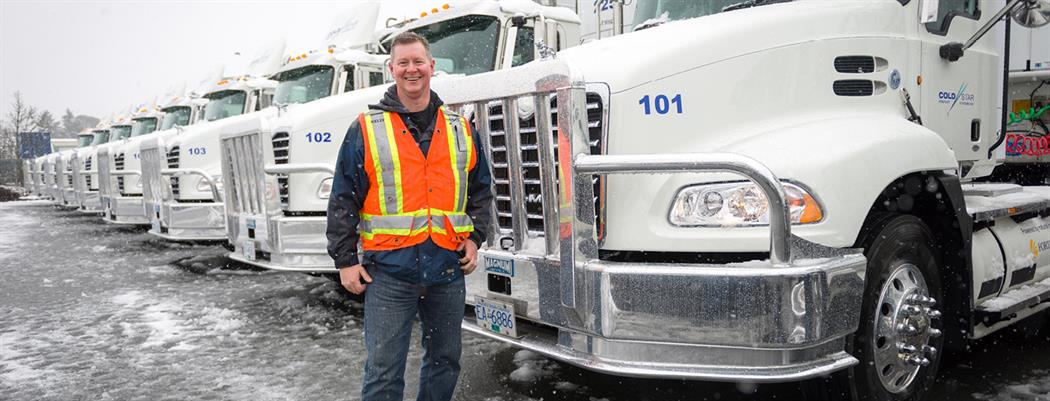Kelly Hawes, president of Cold Star Freight Systems is standing in from of a fleet of CNG trucks (18-150.10)