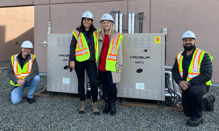 The program team, Jim Kobialko (left), Marysol Escamilla (middle left), Mila Barbour (middle right) and Rav Deol (right), are standing in front of the commercial natural gas heat pumps currently being piloted. (20-015.1)