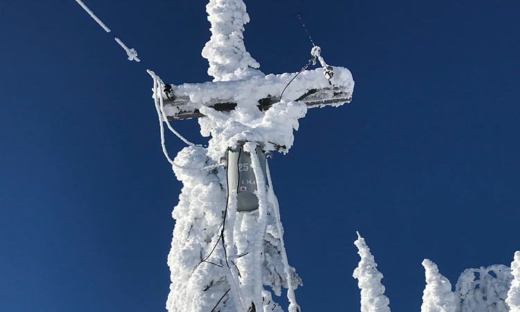 Snow covering a power line pole.